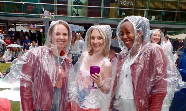 3 women at festival in rain ponchos