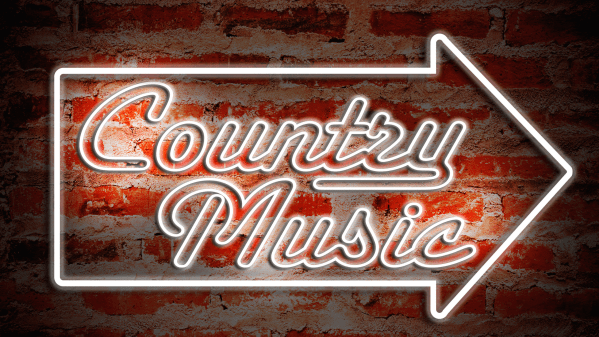 brick wall with neon country music sign and arrow.