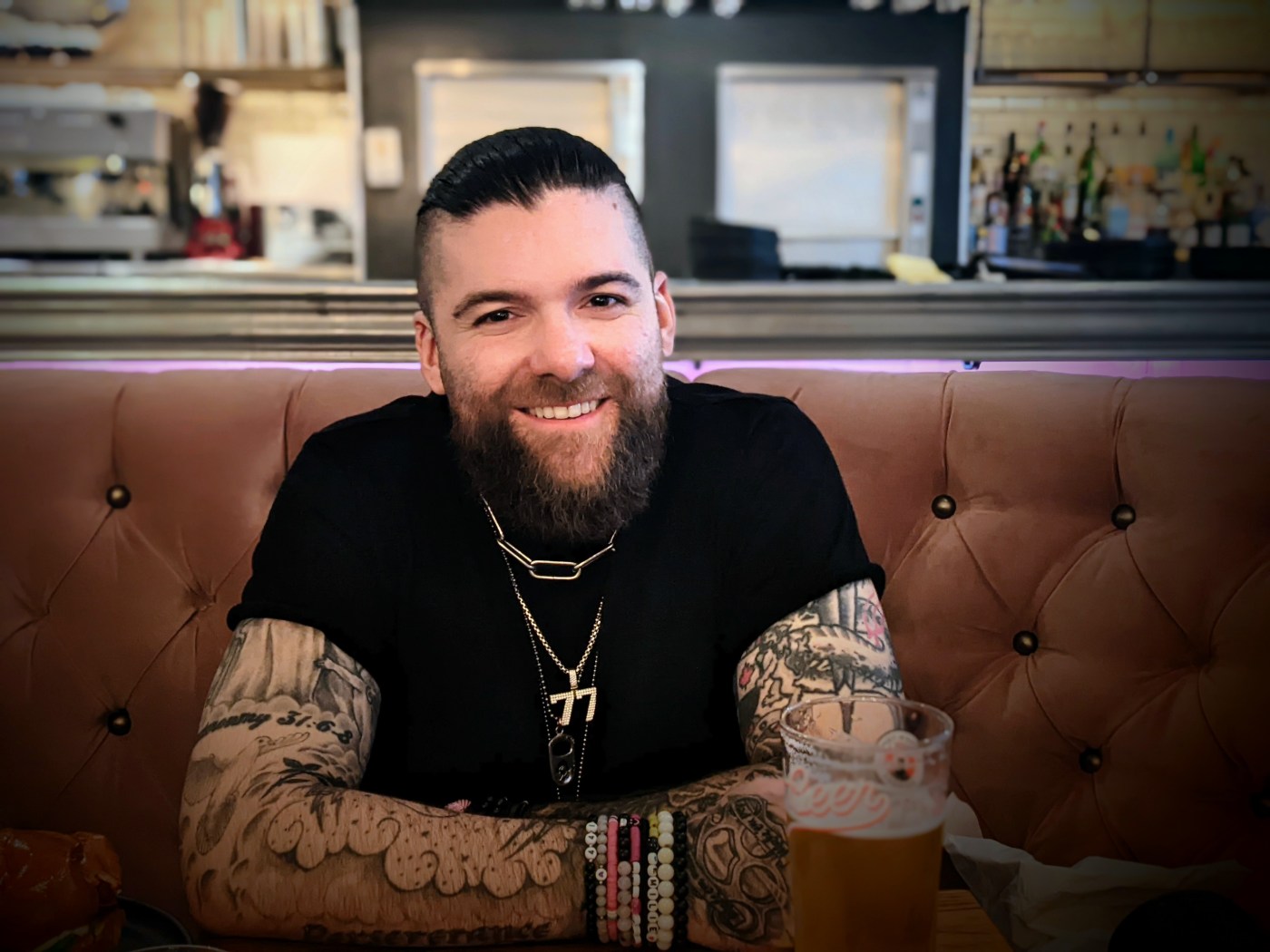 Manny Blu on pink sofa smiling